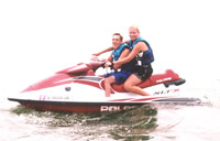 Photo of a young man with a disability and a program volunteer on a watercraft.