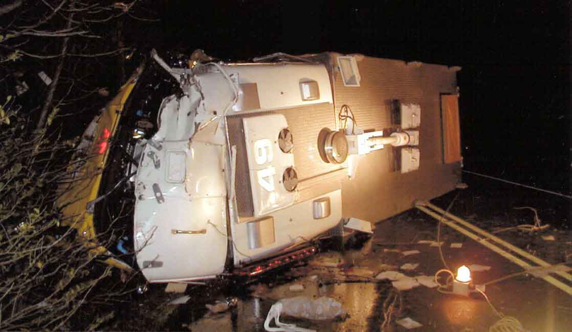 Photo 1.  Photograph of Rescue 1 shortly after impact with the tree.  Photograph was taken of the truck lying on its driver’s side.