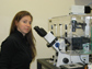 Photo of Susannah Gordon-Messer working on the fluorescence microscope used for her research.