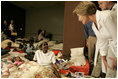 Laura Bush leans down to comfort a woman and her young child inside the Cajundome at the University of Louisiana in Lafayette, Friday, Sept. 2, 2005, during her visit to the center, one of many created to accommodate victims of Hurricane Katrina.