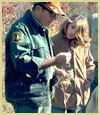 [Photograph]: A Forest Service employee is helping a vacationer.