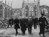 Prime Minister Winston Churchill walks . . . through the ruins of Coventry Cathedral . . . ,