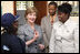 Mrs. Laura Bush, joined by Guerda Previlon, right, chief of party IDEJEN, and Gabriel Bienime, Haiti Education Minister, visits with a student enrolled in the IDEJEN educational program at the College de St. Martin Tours Thursday, March 13, 2008, in Port-au-Prince, Haiti. Mrs. Bush told students and teachers that it is "really important for students to realize they need to keep going, to study more, and really to complete school."