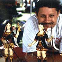 Artist David Nabor Lucero with his painted carved bultos, 1998
