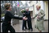 President George W. Bush and Russia President Vladimir Putin embrace in the background as Mrs. Bush reaches out to Ludmila Putina, Russia's first lady, as the Bushes arrived Sunday, May 8, 2005, at the Putin residence shortly after their arrival in Moscow.