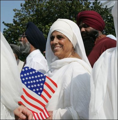 A guest attending the official arrival of India's Prime Minister Dr. Manmohan Singh, holds an American and India flag, Monday, July 18, 2005, on the South Lawn of the White House. 