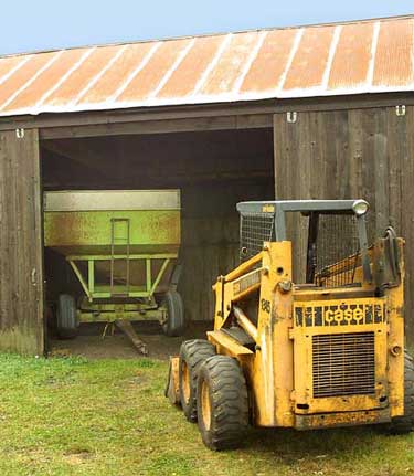 Photo 1 – View of the skid-steer loader, grain wagon, and machine shed (loader backed up six feet).