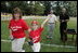 A player from the Challenger Phillies from Middletown, Delaware celebrates receiving a baseball from President George W. Bush and Cal Ripken Jr. at Tee Ball on the South Lawn at the White House on Sunday July 11, 2004.