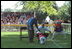 President George W. Bush and Commissioner Cal Ripken signal a "safe" for a player who took an unplanned slide as he ran toward them for his courtesy baseball and photo after the game Sunday, May 5, 2002.