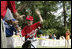 A player from the West University Little League Challengers from Houston, Texas, is welcomed as he crosses homeplate to score a run, Sunday, July 24, 2005, during a Tee Ball game on the South Lawn of the White House.