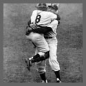 A baseball catcher hugging a pitcher.