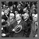 Herbert Hoover and presidential party standing, with men holding their hats, at opening baseball game.