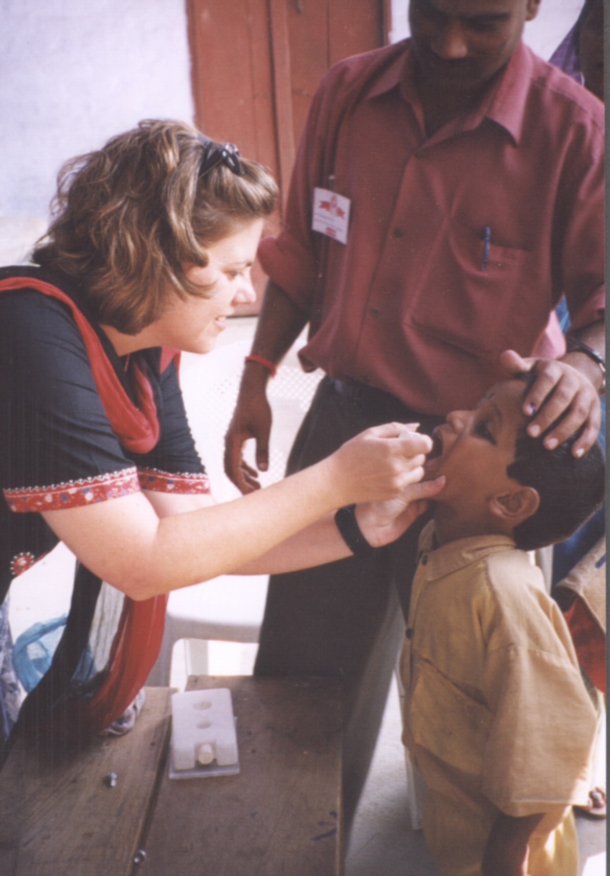 STOP Team member giving oral polio vaccine to child in India