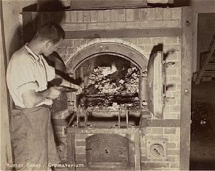 A survivor stokes smoldering human remains in a crematorium oven that is still lit. Dachau, Germany, April 29-May 1, 1945.