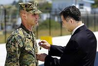 Assistant Secretary of the Navy Richard Greco, right, awards the Navy Cross to Sgt. Copeland
