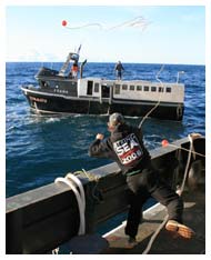 Chief Bos'n Sliney tosses line to fishing vessel