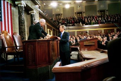 President George W. Bush hands Vice President Dick Cheney and Speaker of the House Dennis Hastert (not pictured) a copy of his State of the Union Address upon his arrival to the House Chamber at the U.S. Capitol Tuesday, Jan. 28, 2003. 