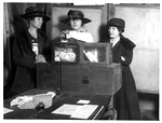 Three suffragists at a voting box