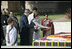 President George W. Bush and Laura Bush sprinkle flowers on the south side of the Mahatma Gandhi Memorial Thursday, March 2, 2006, during a wreath-laying ceremony in Rajghat, India.