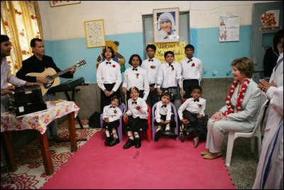 Mrs. Laura Bush listens to a children's choir, Thursday, March 2, 2006, during her visit to Mother Teresa's Jeevan Jyoti (Light of Life) Home for Disabled Children in New Delhi, India.