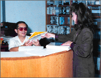 a woman handing some mail to a man across a desk