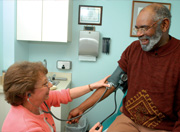 woman taking man's blood pressure