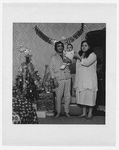Carmen and Pam Gangarossa with infant daughter, full-length portrait, standing, facing front, at Christmas