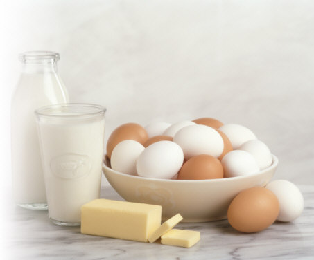 White and beige shell eggs and milk in glass and bottle representing minerals