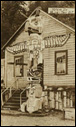Kwakiutl totem pole in front of house, Alert Bay, British Columbia, ca 1900.