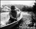 Quileute man named Talicas Eastman making a canoe, Quileute Reservation, Washington, 1905.