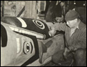 Tlingit man painting totem pole, Saxman, Alaska, 1938.