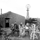 A family sits outside their house on the Nebraska plains.