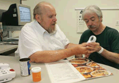 Low-vision therapist Steve Rinne (left) works with veteran Clarence Mikus at the VA Medical Center in Hines, Ill. Mikus is learning how to use a pocket magnifier to read small print on items such as labels, menus and pill bottles