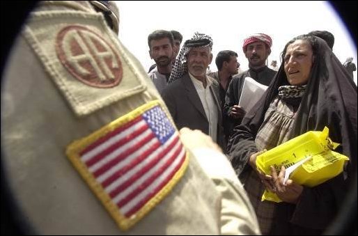 An U.S. Army soldier of the 82nd Airborne Division gives humanitarian aide rations to local civilians of As Samawa, Iraq, on April 5, 2003. (U.S. Army photo by Sgt. Kyran V. Adams) 