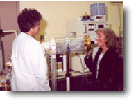 Scientist and worker using a lung capacity measuring machine.
