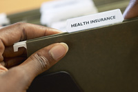 Hand with health insurance folder