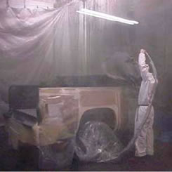 image of worker spraying texturizing coat with protective equipment.