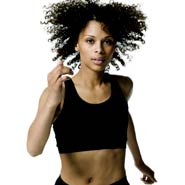 A young woman in a black workout outfit as she runs