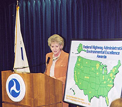 FHWA Administrator Mary E. Peters stands at a podium to present the Excellence in Environmental Streamlining award