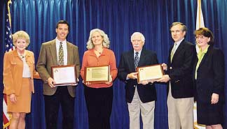 The award presenters stand with the recipients, who are holding plaques