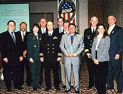 Ten Navy personnel and Chairman Nau pose with the Chairman's Award