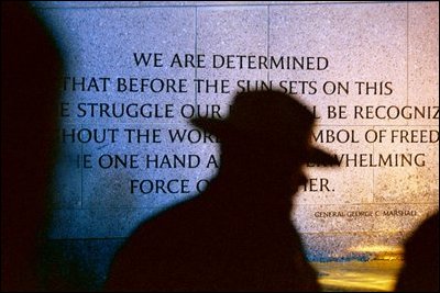 National Park Service Ranger Mike Balis leads a tour near the north end of the memorial plaza. The quote on the Northern Wall by General George C. Marshall states: .We are determined that before the sun sets on this terrible struggle our flag will be recognized throughout the world as a symbol of freedom on the one hand and of overwhelming force on the other.. 