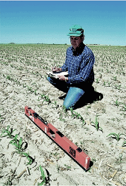 Researcher collects electromagnetic conductivity data to assess water and nitrogen levels in soil.