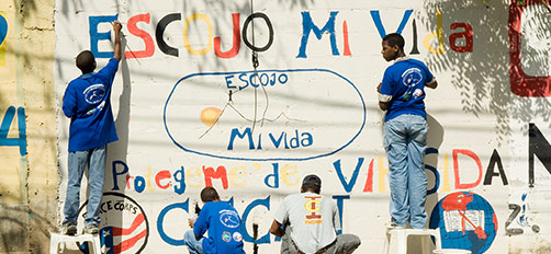 Volunteers and Locals Painting a Wall