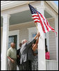 President George W. Bush helps hang a flag outside the new home of Gen White, Wednesday, Aug. 29, 2007, at a new housing development in New Orleans, during President Bush’s visit to New Orleans and the Gulf Coast region on the second anniversary of Hurricane Katrina. U.S. Secretary of Housing and Urban Development Alphonso Jackson is seen at left. White House photo by Shealah Craighead