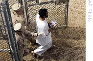 Guards escort a Guantanamo detainee at the Camp 4 detention facility in Guantanamo Bay, Cuba, 18 Nov 2008