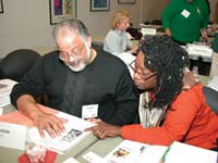 Image of a man and woman sitting at a table discussing financial services.