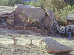 A large boulder which has demolished a portion of a house