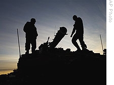 Israeli soldiers stand on a tank at a staging area near Israel's border with Gaza, in southern Israel, Wednesday, Jan. 14, 2009