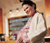 Pregnant woman holding her stomach smiling